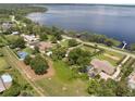 Stunning aerial view of waterfront property with private pool, tennis court, and lake access at 12130 Lakeshore Dr, Clermont, FL 34711