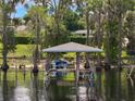 Picturesque boat dock on the water, surrounded by cypress trees draped with Spanish moss at 12130 Lakeshore Dr, Clermont, FL 34711