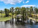 Scenic view of the covered boat dock in tranquil lake setting at 12130 Lakeshore Dr, Clermont, FL 34711