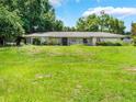 Charming single-story home with a large front yard and mature trees at 12130 Lakeshore Dr, Clermont, FL 34711
