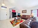 Comfortable living room with tile flooring, leather sofas, a TV, and a welcoming atmosphere at 12300 Abberton Ct, Orlando, FL 32837