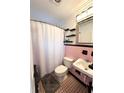 Bathroom featuring pink tiling, a shower with curtain, and decorative mirror at 1400 Yates St, Orlando, FL 32804