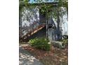 Condo exterior with stairs leading to upper unit and natural landscaping at 190 Riverbend Dr # 102, Altamonte Springs, FL 32714