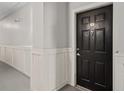 Condo front door with visible unit number and white wainscoting on the hallway walls at 206 E South St # 6007, Orlando, FL 32801