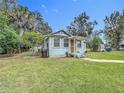 Cozy home with a well-manicured lawn, surrounded by lush greenery and mature trees at 211 N Randolph Ave, Kissimmee, FL 34741