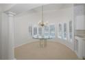 Bright dining room with large windows, plantation shutters and elegant chandelier lighting at 235 Promenade Cir, Lake Mary, FL 32746