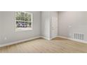 Bright room with light wood floors, white trim, a window, and a door at 3678 Rollin O Ln, Apopka, FL 32703