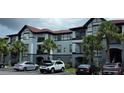 A spacious condo building featuring multiple units, balconies, and a parking area with several vehicles at 3724 Castle Pines Ln # 4234, Orlando, FL 32839