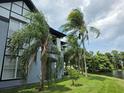 A view of a two-story condo building with a water view and swaying palm trees at 5501 Pga Blvd # 4723, Orlando, FL 32839