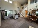 Spacious living room with high ceilings, carpeted floor, a staircase, and comfortable seating area at 6224 Zane Dr, Mount Dora, FL 32757