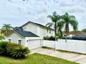 View of home with well-manicured lawn, white fence, and a two car garage, perfect for Gathering living at 7727 Glynde Hill Dr, Orlando, FL 32835