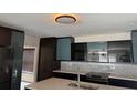 Modern kitchen features sleek dark cabinets, stainless steel appliances, and stylish backsplash, creating a contemporary look at 7727 Glynde Hill Dr, Orlando, FL 32835