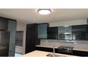 Modern kitchen features sleek dark cabinets, stainless steel appliances, and stylish backsplash, creating a contemporary look at 7727 Glynde Hill Dr, Orlando, FL 32835