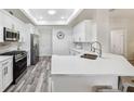 Modern kitchen featuring white cabinetry, stainless steel appliances, and a breakfast bar with quartz countertops at 8473 Granada Blvd, Orlando, FL 32836