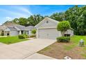 Well-maintained home featuring an attached two-car garage and landscaped front yard at 907 Pearly Ridge Ln, Lakeland, FL 33809