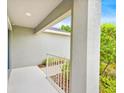 Covered front porch with white railing offers a shaded entry with a glimpse of lush greenery at 907 Pearly Ridge Ln, Lakeland, FL 33809