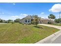 Sprawling front yard with a well-maintained lawn and mature landscaping around the perimeter of the home at 9426 Burnam Dr, Weeki Wachee, FL 34613