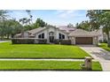 Inviting single-story home boasts a lush green lawn and mature trees, offering a picturesque setting at 9774 Bohart Ct, Orlando, FL 32836