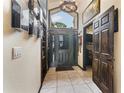Grand foyer features tile flooring, a striking wood door, and built-in bookshelves at 9774 Bohart Ct, Orlando, FL 32836