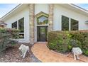 Welcoming front entrance with decorative lion statues, a tiled walkway, and lush landscaping at 9774 Bohart Ct, Orlando, FL 32836