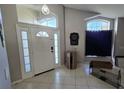 Bright foyer featuring high ceilings, transom windows, and sidelights flanking the front door at 12938 Maribou Cir, Orlando, FL 32828