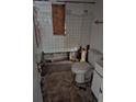 Damaged bathroom with a toilet, missing tiles, and exposed plumbing requiring renovation at 134 Flamingo Dr, Auburndale, FL 33823