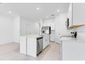 Contemporary kitchen featuring white cabinets, an island with a sink, and stainless steel appliances at 134 River Front Way, Edgewater, FL 32141