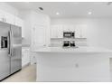 Bright kitchen featuring white cabinets, stainless steel appliances, and a large center island at 134 River Front Way, Edgewater, FL 32141