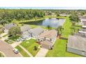 Aerial view of a two-story home with a lake view surrounded by lush trees and greenery at 13404 Bradwater Ct, Orlando, FL 32828