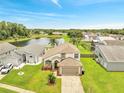 Aerial view of a two-story home with a lake view and a well-manicured lawn and landscape at 13404 Bradwater Ct, Orlando, FL 32828