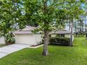 Inviting single-story home with mature trees, green lawn, and an attached two-car garage at 142 Stonegate Pass, Davenport, FL 33897