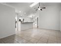 Open-concept layout showcasing the living room with tile flooring and views of the kitchen at 142 Stonegate Pass, Davenport, FL 33897