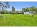 Expansive, well-maintained back yard with lush green grass, trees, and a screened in patio at 1507 Golfside Dr, Winter Park, FL 32792