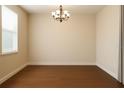 Empty dining room with hardwood floors, a chandelier, and natural light from a window at 15483 Avenue Of The Arbors, Winter Garden, FL 34787