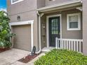 Charming home exterior featuring a well-manicured lawn, attached garage and covered front porch at 2005 Compass Flower Way, Ocoee, FL 34761