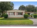 Charming home featuring large windows, well-kept lawn, and mature trees at 2060 Lamplight Cir, Mount Dora, FL 32757
