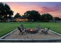 Relaxing backyard featuring a fire pit with seating, surrounded by a spacious lawn and mature trees at 2106 Ridgewind Way, Windermere, FL 34786
