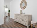 Inviting entryway with wood floors, stylish cabinet, decorative mirror, and stool at 2363 Lancashire St, Davenport, FL 33896
