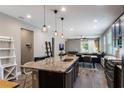 Modern open-concept kitchen with a granite island, stainless steel appliances, and an adjacent dining area at 245 Bella Verano Way, Davenport, FL 33897