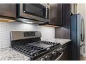 Close-up of modern kitchen details, including stainless steel appliances, granite countertops, and a stylish tile backsplash at 245 Bella Verano Way, Davenport, FL 33897