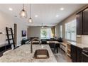 Modern open-concept kitchen with a granite island, stainless steel appliances, and an adjacent dining area at 245 Bella Verano Way, Davenport, FL 33897