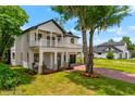 Charming two-story home features a manicured lawn, brick driveway, and inviting front porch with second-story balcony at 2607 Lafayette Ave, Winter Park, FL 32789