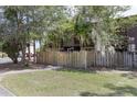 Townhome with a wooden fence and lush trees providing a serene view from the front yard at 2636 Crown Ct, Kissimmee, FL 34741