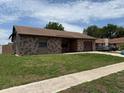 Single-story home featuring a stone facade and an attached garage at 2842 Blind Owl Dr, Orlando, FL 32822