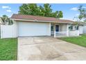 Charming single-story home with a two-car garage, well-maintained lawn, and picket fence at 2871 Milstead St, Orlando, FL 32837