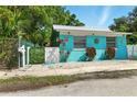 Charming bright blue single-story home with a metal roof and decorative accents at 318 Palm St, New Smyrna Beach, FL 32168