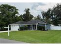 Beautiful home with green lawn and mature trees under a cloudy sky at 358 2Nd St, Geneva, FL 32732