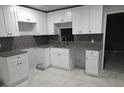 Modern kitchen featuring granite countertops, sleek white cabinets and stainless steel sink at 4 N Christiana Ave, Apopka, FL 32703