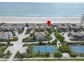 Overhead view of the neighborhood, beach, tennis courts, and blue ocean at 4365 S Atlantic Ave # B8, New Smyrna Beach, FL 32169