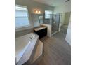 Spacious bathroom with a soaking tub, glass-enclosed shower, and elegant tiled floors at 4624 Via Veneto Ct, Kissimmee, FL 34746